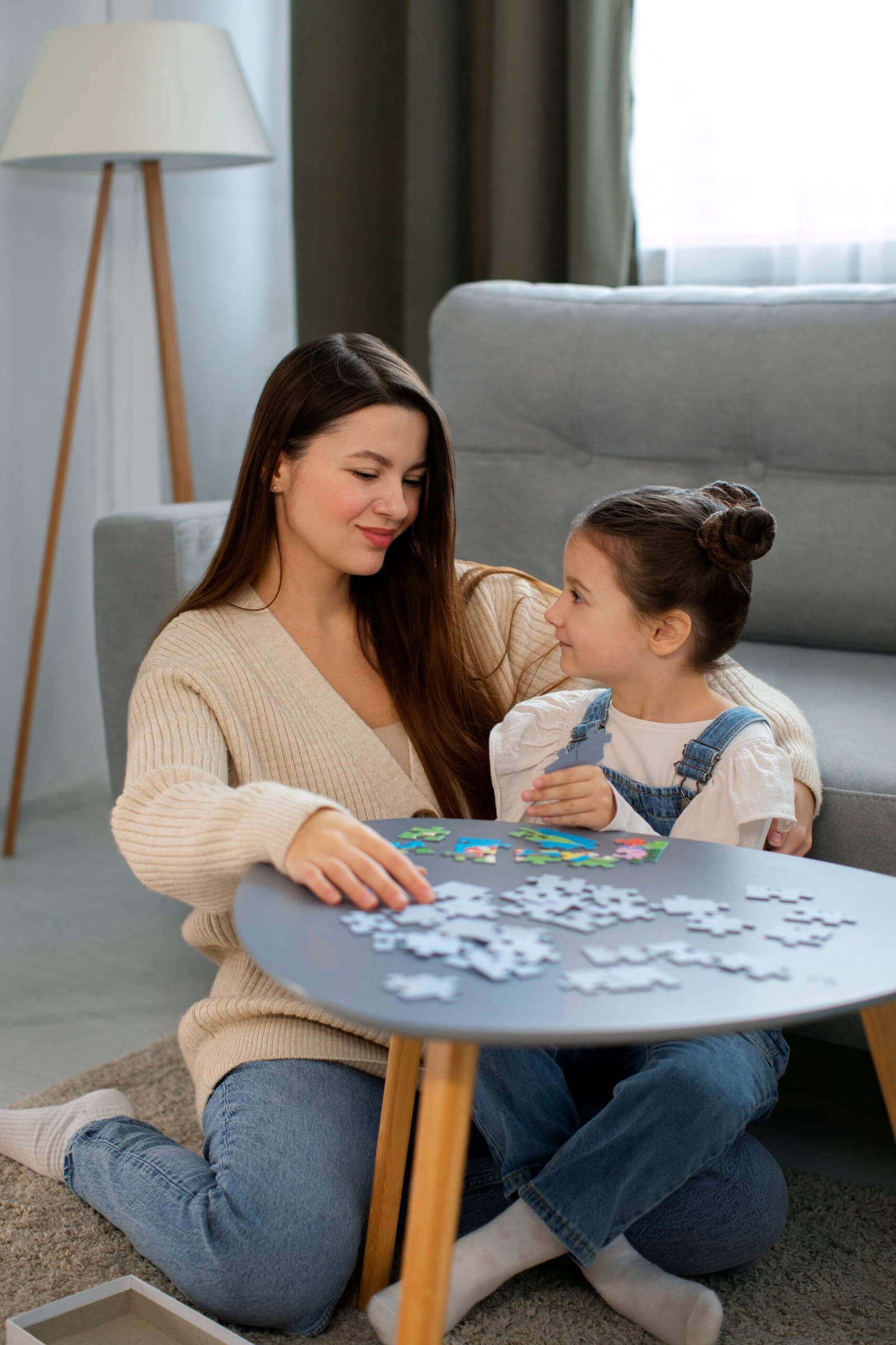 A mother and daughter playing a game together at a table