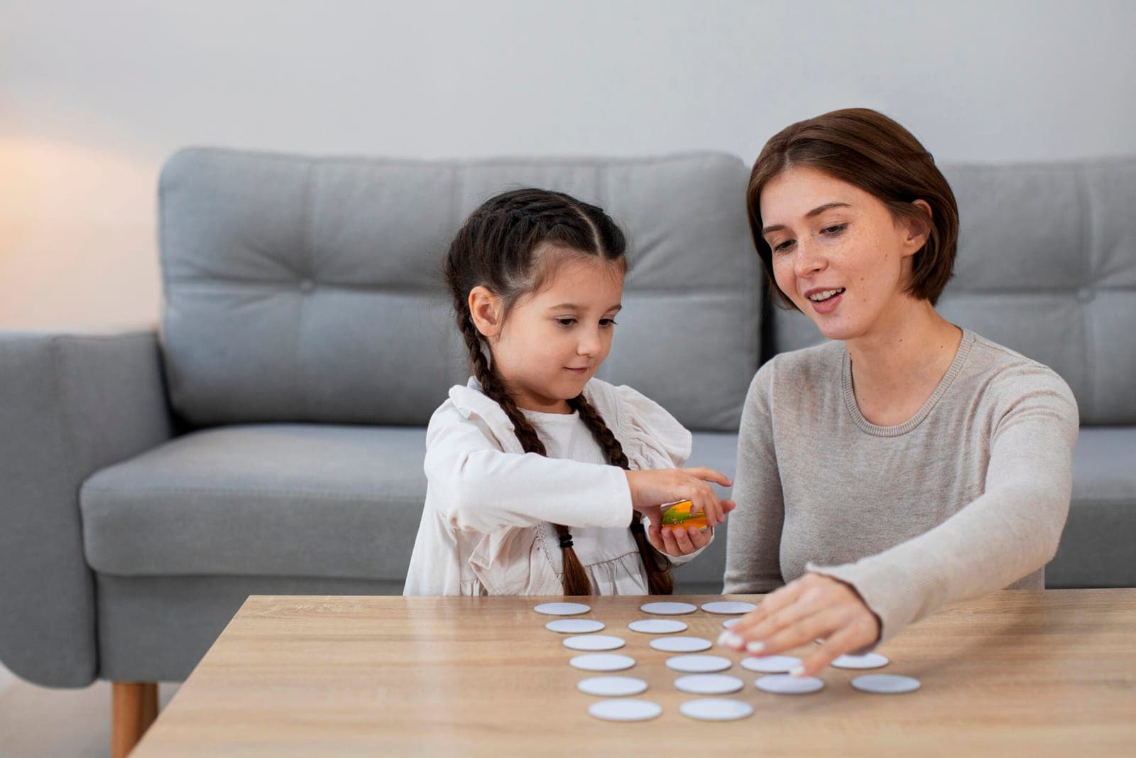 A mother and her young daughter playing together on the floor